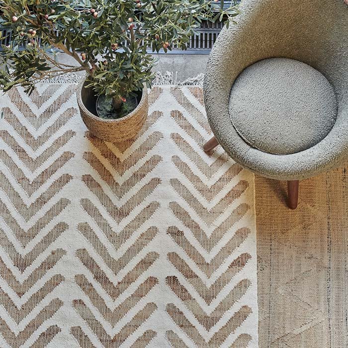 Cotton and jute rug woven in cream and brown tones with geometric design.