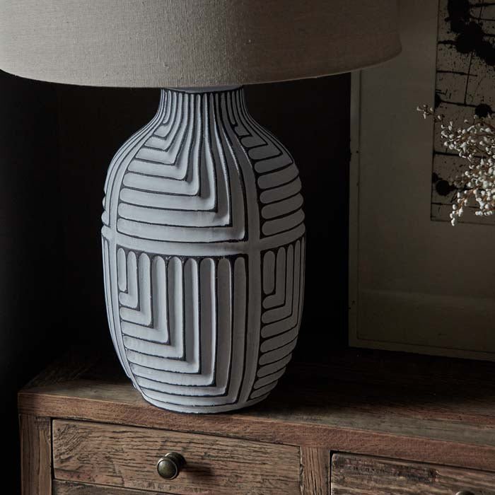 Engraved line pattern on grey and white table lamp base.