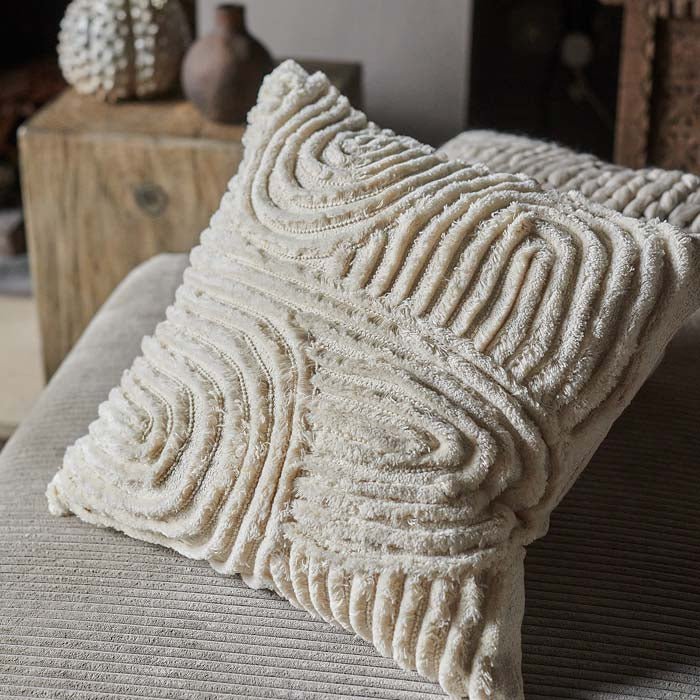Cream square cushion with a curved tufted line pattern