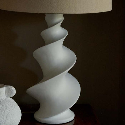 White spiral shaped lamp base with a cream lampshade