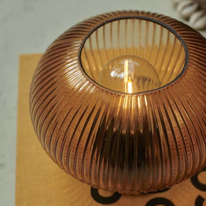 Circular ribbed glass led lamp in amber switched on