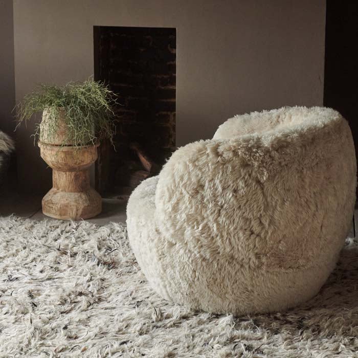 Furry cream sheepskin armchair sat on a shaggy rug