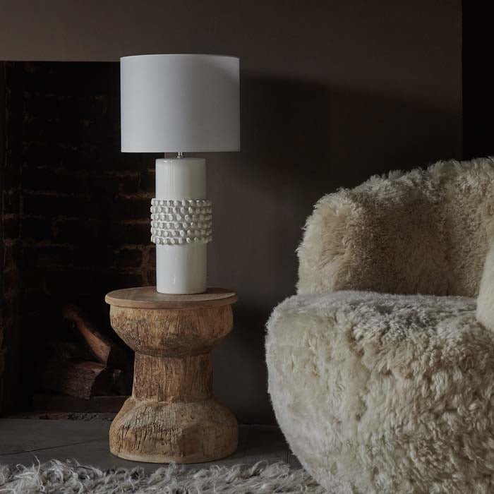 Tavira Bobble Table Lamp, a smooth and bobbled white glazed ceramic table lamp styled on a spool shape wooden side table.