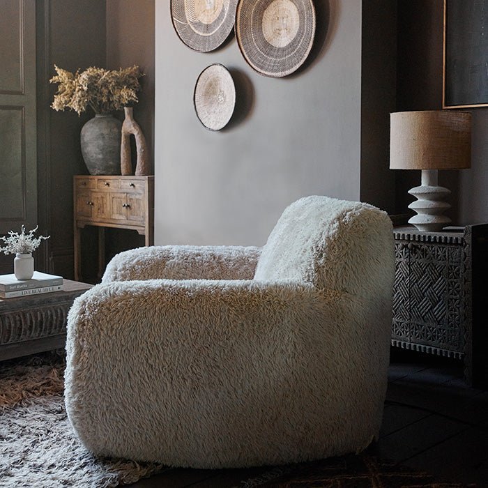 Cream faux fur armchair with an oversized cushioned design, soft textured upholstery and a relaxed curved silhouette. Saskia Cream Faux Fur Armchair by Abigail Ahern, created for ultimate comfort with a cosy statement look that adds warmth and texture to modern interiors. A luxury accent chair perfect for living rooms, bedrooms and reading corners, bringing timeless style, inviting comfort and a sophisticated focal point to contemporary home decor.