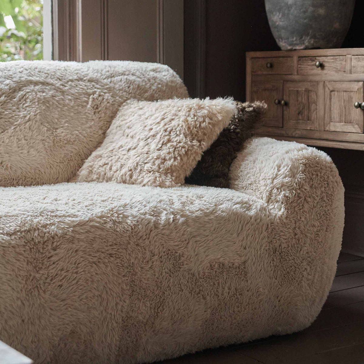 A closeup of the soft cream faux fur upholstery of the Saskia Sofa.