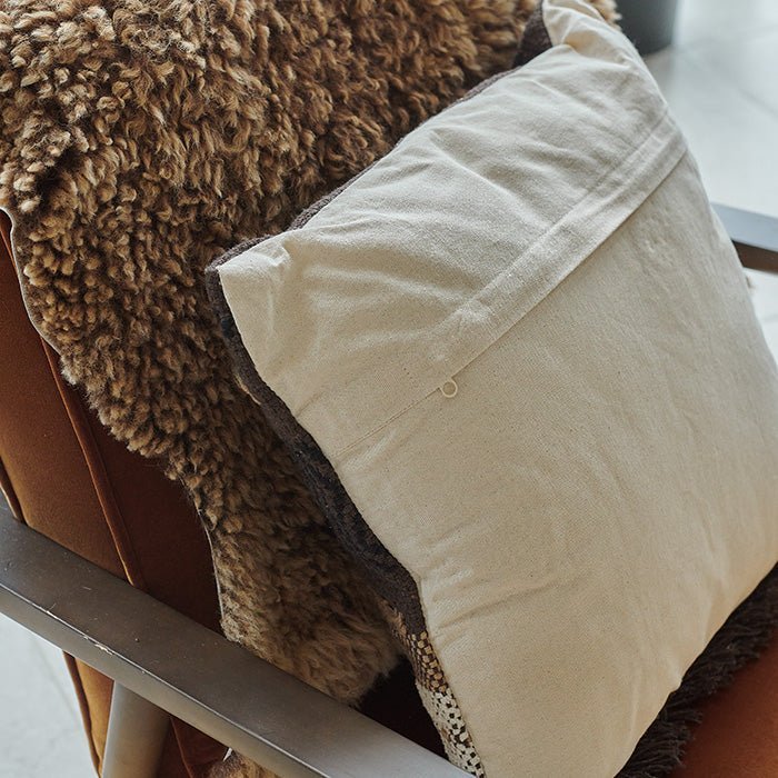 A closeup of the back of the Piper Cushion showing the zip hidden by a pleated seam.