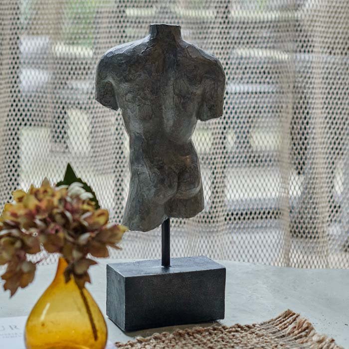 The Adonis Scultpure, a polyresin model of a male torso with a faux metal finish mounted on a small plinth