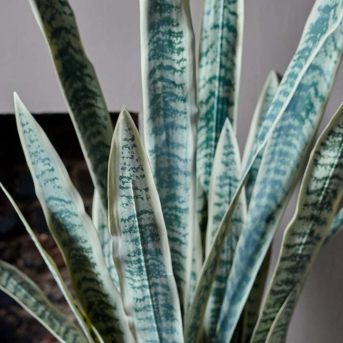 A closeup of the dtail on the long pointed leaves of the Artificial Snake Plant in Pot, a tall faux plant.