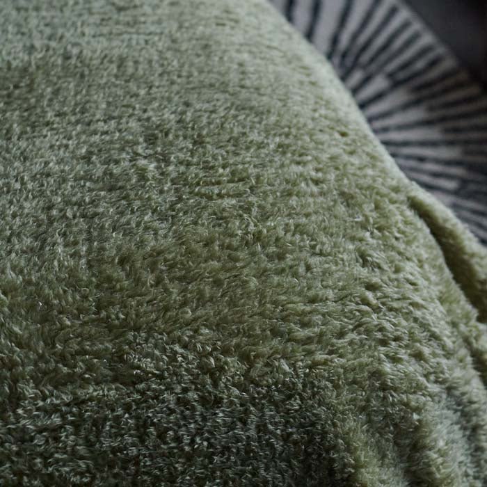 A closeup of the super-soft and snuggly sage green-hued fabric of the Winona Blanket - Sage.
