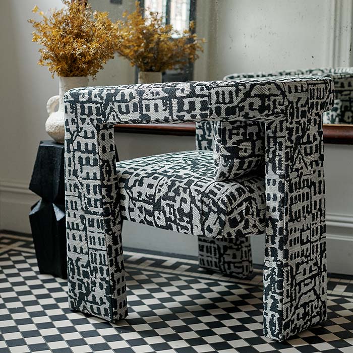 Back view of the Black and white patterned armchair with a distinctive abstract print, upholstered linen blend fabric and contemporary three-legged silhouette. Bushwick Patterned Armchair by Abigail Ahern, designed as a statement accent chair for modern living rooms, bedrooms, dining spaces and home offices. A luxury occasional chair that adds character, texture and bold designer style to contemporary interiors.