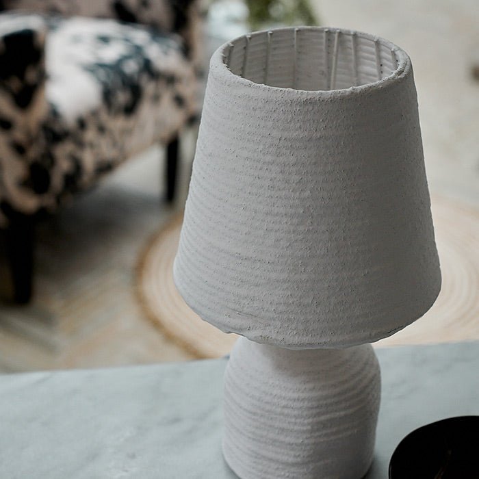 Detail of the ribbed texture on a small white paper mache table lamp.