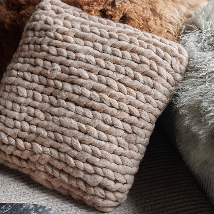 A closeup of the soft natural blush coloured Riva Cushion, showing the chunky knit woven detail on the front.