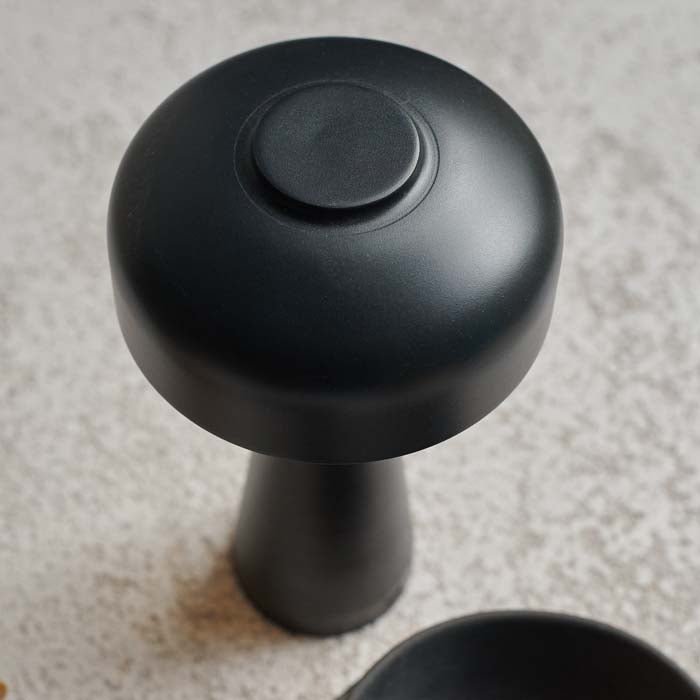 Detail image of the curved dome top of a black coloured rechargeable table lamp.