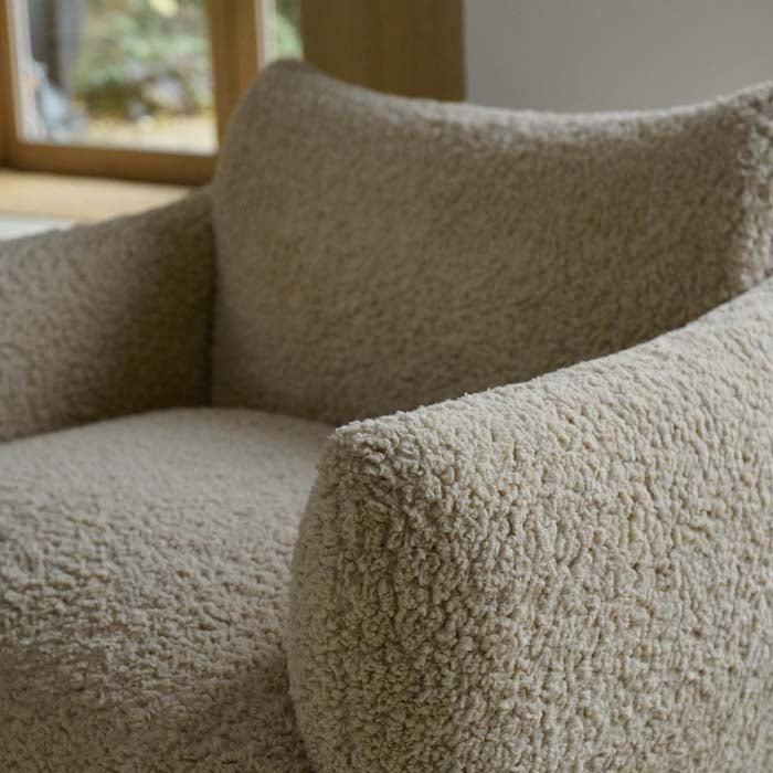Cream boucle armchair with a soft textured fabric finish, comfortable cushioned seat and contemporary structured silhouette. Belville Armchair by Abigail Ahern, crafted in a luxurious boucle upholstery designed to create a cosy and stylish focal point in modern interiors. A statement accent chair perfect for living rooms, bedrooms and dining spaces, adding warmth, texture and timeless elegance to luxury home decor.