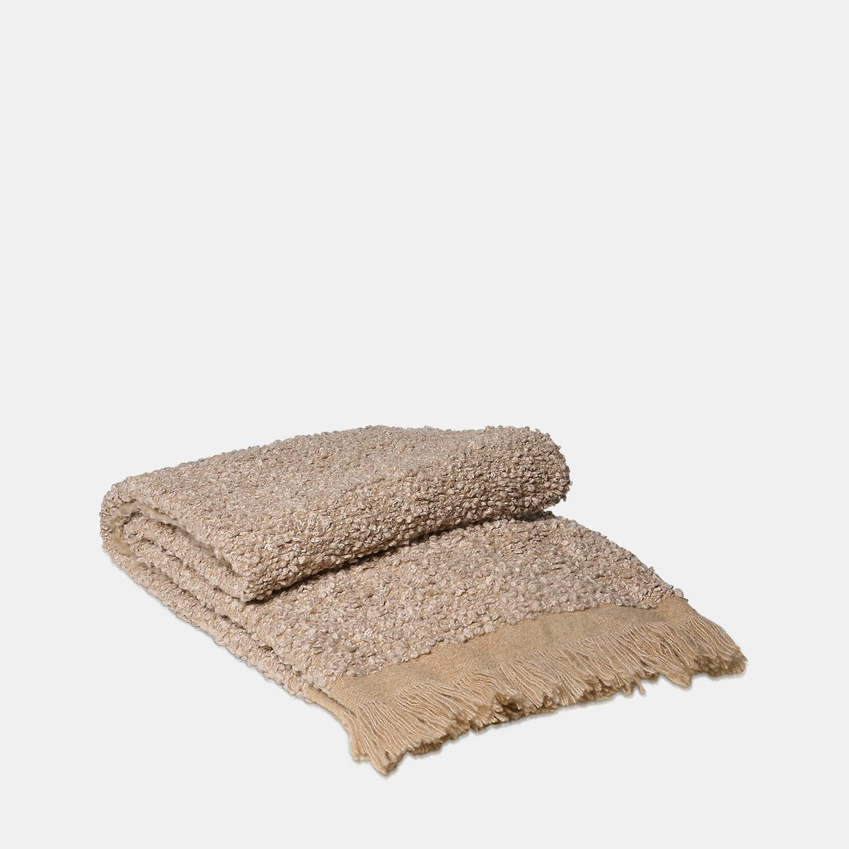 Beige textured blanket with fringes on a light gray background