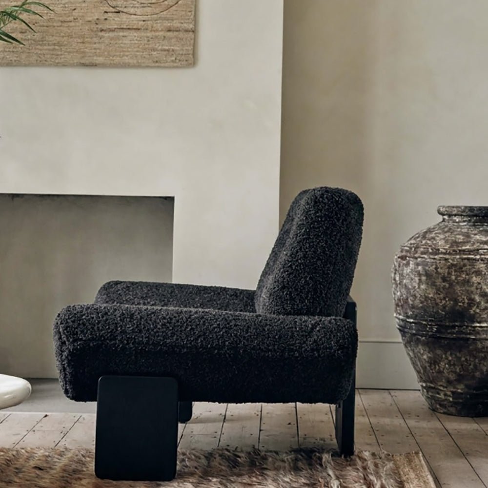Abigail Ahern Axel Faux Shearling Accent Chair in rich charcoal grey, featuring a distinctive modern silhouette with softly curved lines and plush, tactile upholstery. A statement accent chair that adds warmth, texture and personality to modern, eclectic interiors, ideal for a sitting room, bedroom or stylish home office.