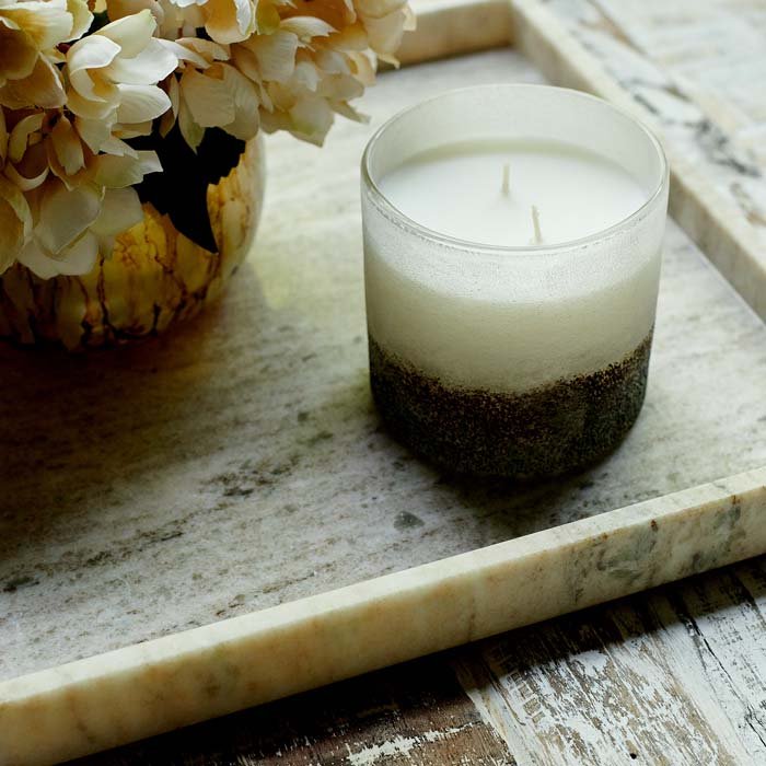 Marble tray decorated with a candle and a vase of flowers.
