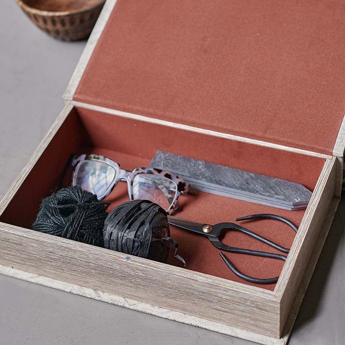 Open storage book, displaying a pair of glasses, scissors, and string.