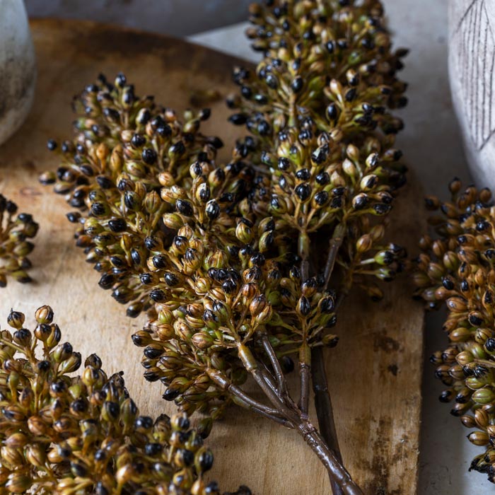 Close up image of the artificial brown floral buds on a faux sorghum stem umber.