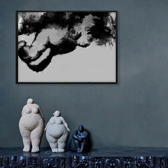Landscape framed print of a black and white nude figure hanging above three sculptures 