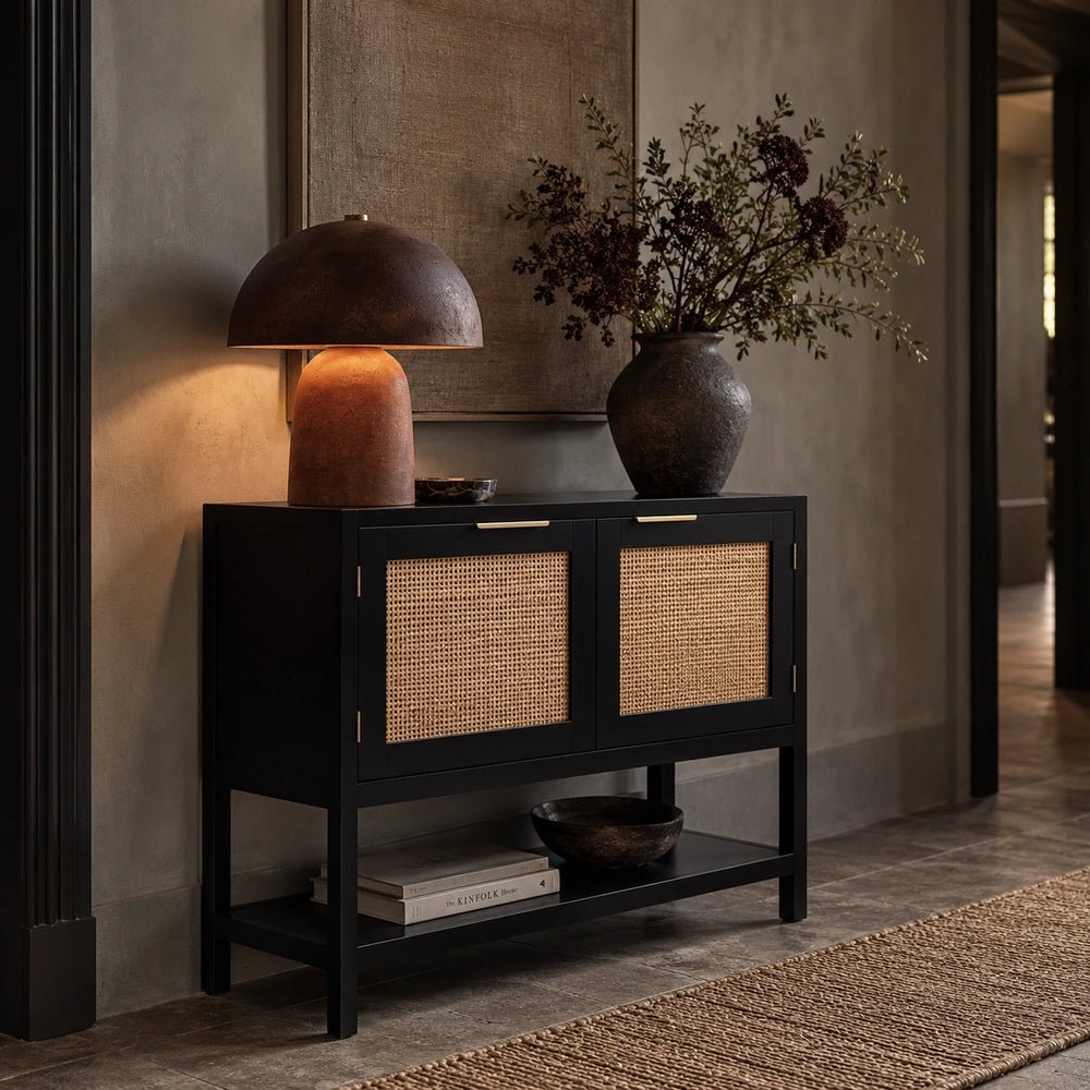 Bailey Black Wood Cabinet with dark textured geometric doors, positioned in a layered contemporary interior with warm neutral furnishings and decorative objects.