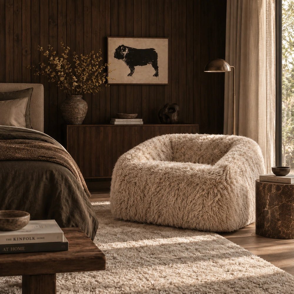 Bertha Faux Fur Armchair with soft cream textured upholstery and rounded silhouette, styled in a warm neutral living room with layered contemporary furnishings.