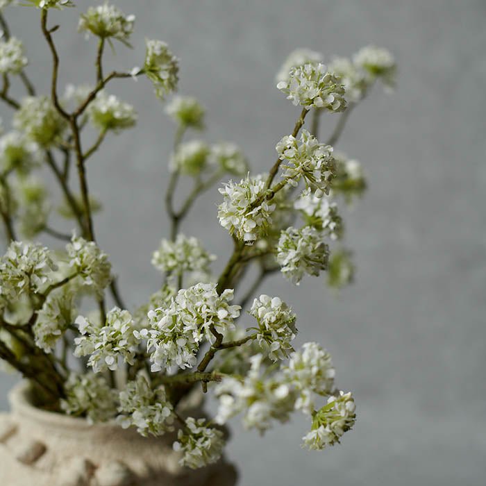 White blossom flowers on an artificial stem.