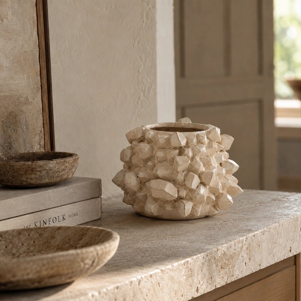 Bricket Textured Vase with tall sculptural form and rough dark surface, styled on a console table with dried branches and layered neutral decorative objects.