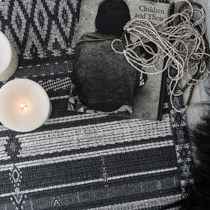 Patterned monochrome vinyl flooring with an LED candle and book placed on top