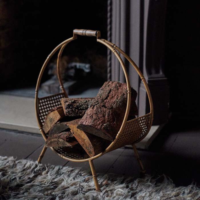 The Cohen Log Holder, a bamboo style round log holder with a rattan bottom and four short legs.