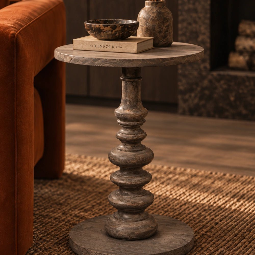 Devon Wooden Side Table with rounded wood top and sculptural pedestal base, positioned beside a neutral sofa in a softly styled contemporary living room.