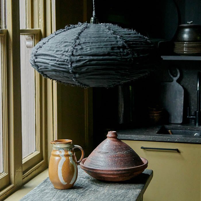 A medium sized fabric lampshade hung low above a kitchen worktop. Luxury lighting from Abigail Ahern that adds a designer look to your home decor. 