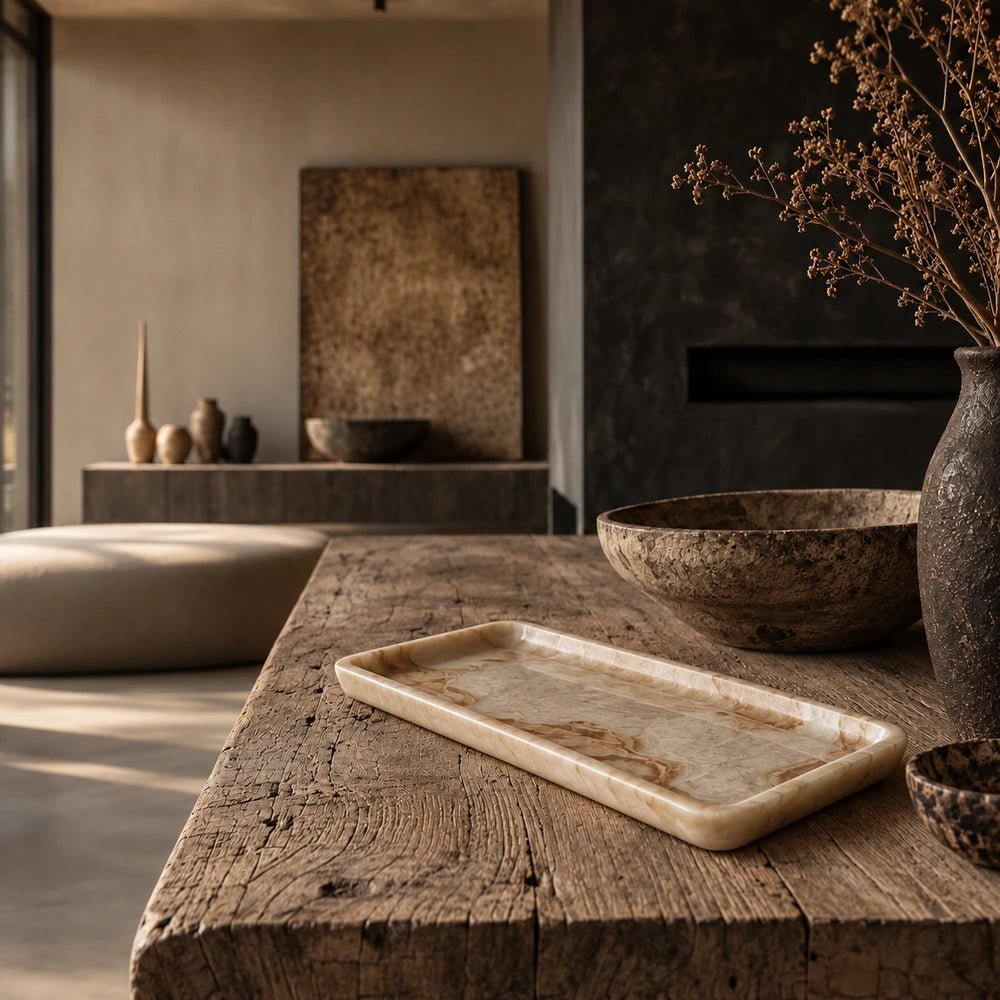 Emery Rectangular Tray with pale marbled surface and raised edge styled on a textured wooden console beside decorative bowls, ceramics and dried foliage.