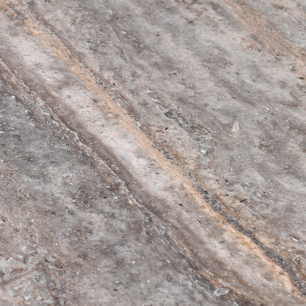 Close-up of the Abigail Ahern Marlen Travertine Dining Table showcasing the unique smoky stone surface, natural tonal variation and richly textured travertine finish.