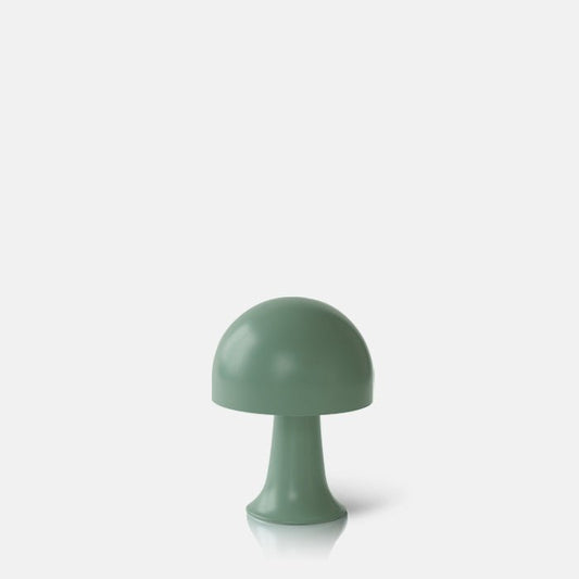 A cutout of a small portable LED table lamp in forest green. Perfect styled on a coffee table with other home accessories, it's the perfect addition to a stylish interior. These dome shaped metal lamps are battery operated, therefore no need for plug sockets. These small curvy lamps are super flexible to pop all over. the house, style next to your bath, bedside or create intrigue to your tablescapes and a dash of colour to your kitchen worktops. 
