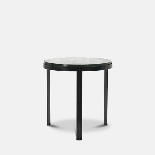 Round side table with clear recycled-look glass table top, black metal frame and three legs.