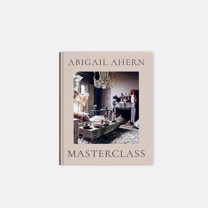 Cutout of Masterclass, an A4 sized hardback book in a neutral tone with front picture of a cosy lounge room in maximalist style