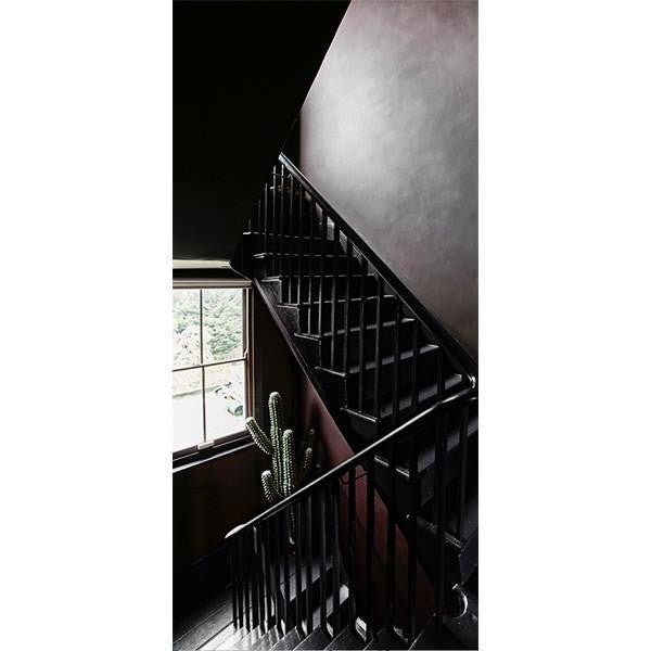 Black wooden staircase with rich red painted walls