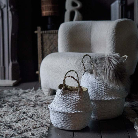 Large and small round handled baskets with a white exterior sat on painted wooden floorboards