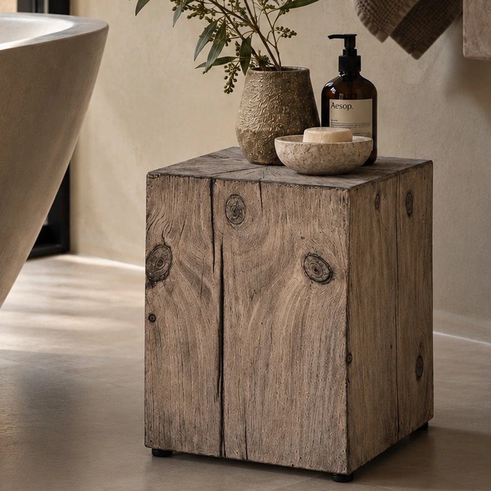 Norton Stool shown against a simple neutral background, highlighting the warm wood-effect surface, rounded seat, compact proportions and distinctive sculptural leg shape.
