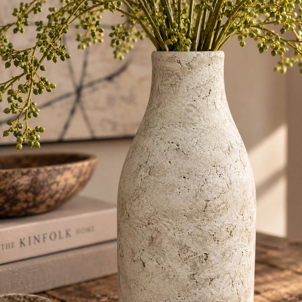 Palmer Cement Vase styled with sculptural branches on a rustic wooden table, showing its dark textured finish, rounded form and organic contemporary silhouette.