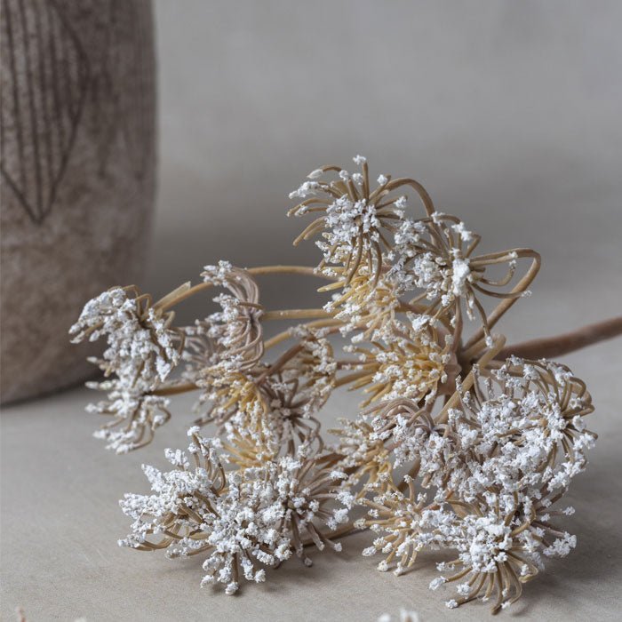 Detail shot of the head of an artificial flower stem with very small fake white buds.