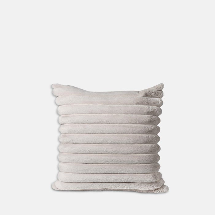 A cutout of the Reva Faux Fur Cushion, a soft cosy cushion in cream faux fur with ridged stitched detailing.