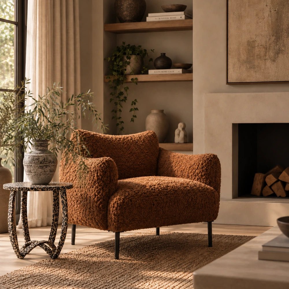 Savannah Leopard Print Side Table in a dark patterned finish, styled beside a rust boucle armchair and large decorative vase in a warm neutral living room.