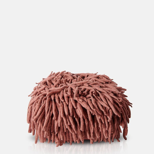 A rust coloured floor pouffe covered in long tendrils of wool.