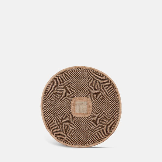 Round woven wall basket with black and natural pattern design.