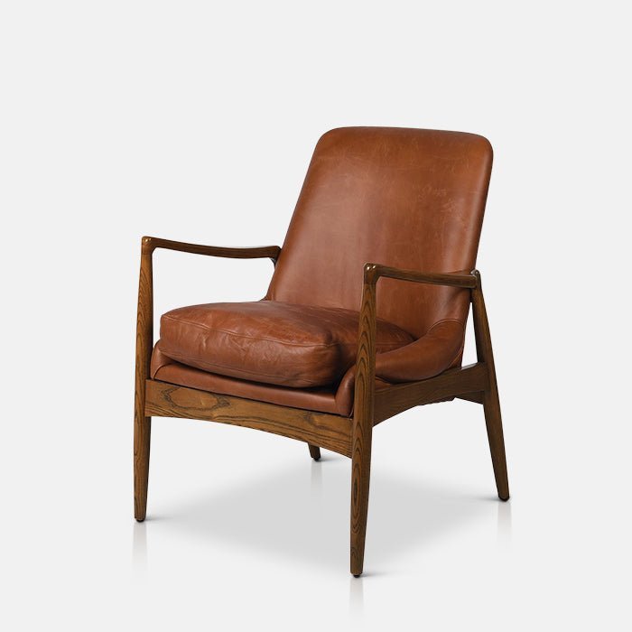 Abigail Ahern Truman Brown Leather Armchair in dark brown leather and ash wood, featuring a curved silhouette, padded seat and backrest with a distinctive mid-century-inspired design.