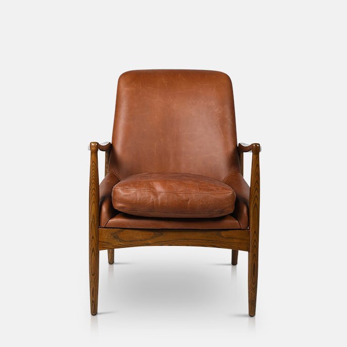 Abigail Ahern Truman Brown Leather Armchair in rich dark brown leather, featuring a beautifully curved mid-century-inspired silhouette and natural ash wood frame, styled as a sophisticated statement chair in a contemporary interior.