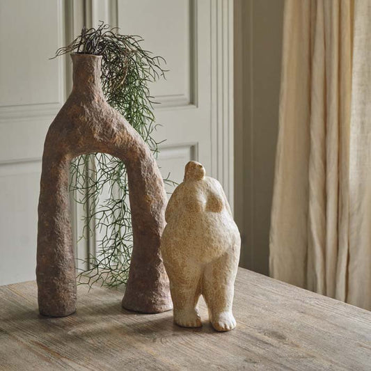 A large standing female sculpture. Cream coloured female figurine styled next to an unusual shaped vase. Female figurine to add an arty look to your home. 