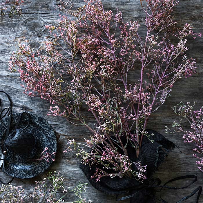 A bunch of tall pink faux flower stems covered in small floral buds.